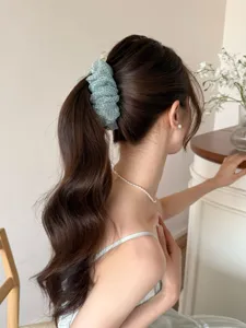 Pince banane en maille à pois vert menthe pour une coiffure élégante en queue de cheval.