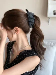 Vue détaillée d'une élégante pince à cheveux banane en tulle noir à pois stylé