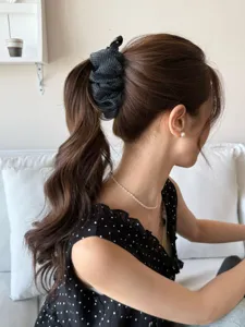 Vue latérale d'une femme portant une pince à cheveux banane en gaze à pois noirs