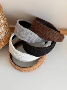 Detailed macro view of various colored woven wide-edge headbands stacked for hair styling