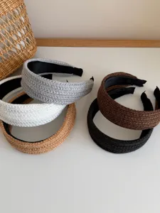 Close-up view of five stylish braided wide headbands in neutral tones for women.