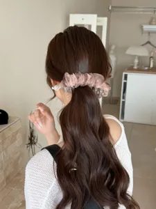 Vue détaillée d'une élégante pince à cheveux en organza à pois sur une queue de cheval