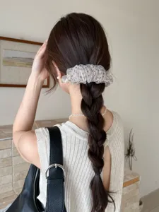 Vue détaillée d'une pince banane élégante en tulle à pois sur une coiffure tressée
