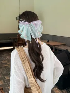 Detalle de pinza para el pelo con lazo de tul de lunares, cintas y colgantes