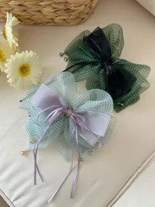 Detalle de pinzas para el cabello con lazo de lunares, cintas y colgantes de perlas