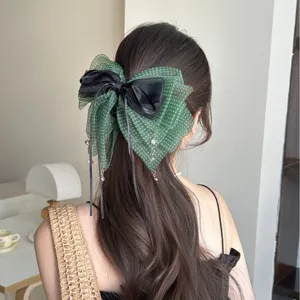 Elegante pinza para el pelo con lazo verde de lunares y colgantes de cristal.