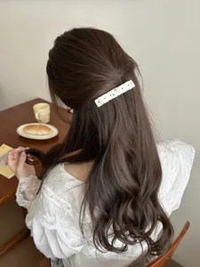 Detailed view of a white polka dot bow hair comb styled in an elegant princess half-up hair