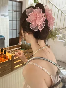 Achteraanzicht van elegante roze mesh haarclip met strik in een gezellige café-omgeving