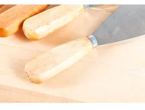 Spatola per stucco con manico in legno vista di dettaglio per lavori di costruzione e pulizia.