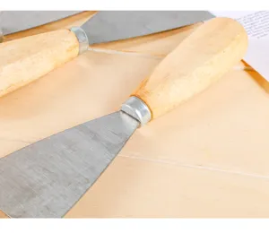 Dettaglio raschietto con manico in legno, lama metallica resistente per lavori edili.