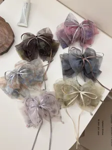 Detailed view of multiple gradient mesh bow hair clips with delicate ribbon accents.