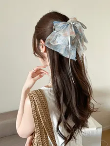 Detail of a blue fairy mesh bow hair clip on long wavy hair