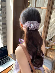 Pinza para el pelo con volantes morados y gema de corazón en cabello largo