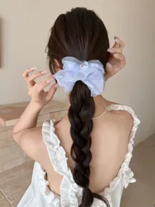 Chouchou élégant en organza bleu clair pour coiffure tressée, détail de mode