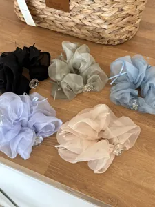 Vue détaillée des chouchous en organza avec ornements en cristal et nœuds élégants