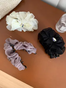 Vista detallada de tres elegantes pinzas para el cabello de gasa con diamantes de imitación