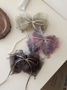 Detailed view of fairy-style dyed mesh bow hair clips with elegant ribbon ties