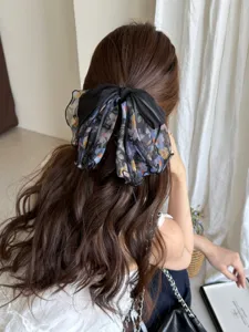 Detailed view of an elegant French style floral mesh bow hair clip on a ponytail