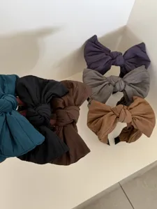 Détail de serre-têtes à gros nœuds unis disponibles en six tons mats élégants et chics