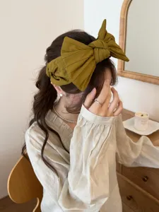 Détail d'un bandeau à gros nœud vert olive pour un effet de sommet de tête haut