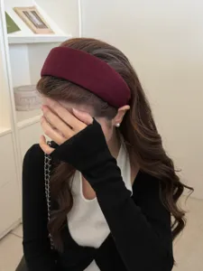 Detalle de una diadema acolchada burdeos con diseño de copa alta y textura suave
