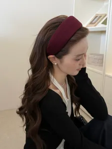 Perfil de una mujer con una elegante diadema ancha burdeos para un look de cabeza alto