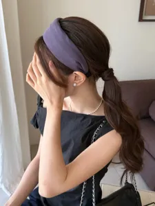 Elegante diadema ancha morada para mujer mostrada en una modelo en un ambiente chic.