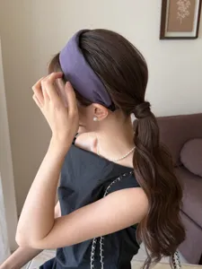 Modelo con una diadema ancha de tela morada para un look de moda para el cabello