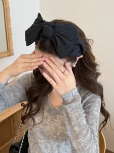 Détail d'un grand bandeau à nœud noir élégant pour femmes pour un look chic et moderne