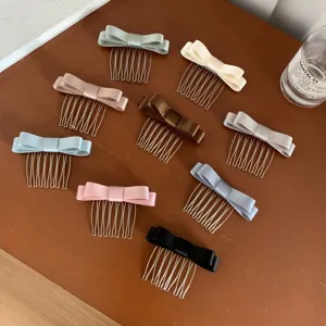 Assortment of elegant satin bow hair insert combs in multiple colors on a wooden table