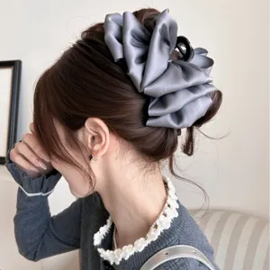 Große graue Haarklammer mit Satinschleife an einem Modell für elegantes Hochstecken.