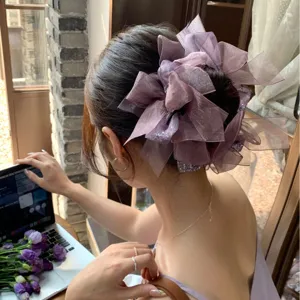 Chouchou grand nœud violet avec strass porté par un modèle