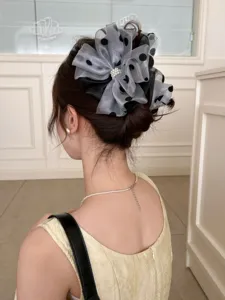 Detailed back view of a large polka-dot mesh bow hair claw clip with elegant pearl detail.