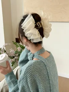 Vue arrière d'une pince à cheveux en tulle blanc cassé sur un chignon élégant