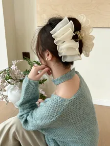 Détail d'une pince à cheveux nuage élégante en tulle plissé crème pour les coiffures