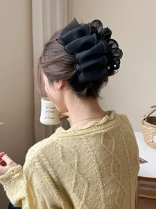 Détail d'une grande pince à cheveux en tulle noir pour coiffures en chignon