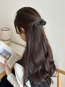 Close-up of a sweet black polka dot bow hair clip styled in a elegant half-up hair