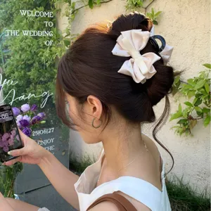Elegant satin bow claw clip with rhinestones for bridal or daily hair styling.