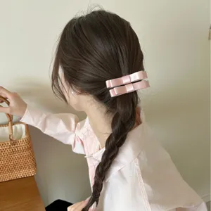 Elegante rosa Satin-Haarspangen mit Doppelschleife für Damen in einer schicken Flechtfrisur