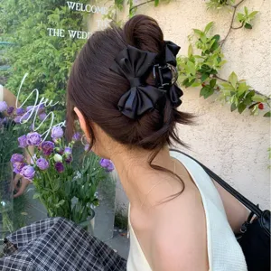 Elegant black satin bow hair claw clip for women's half-up hairstyles in garden