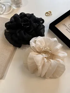 Detailansicht von eleganten Haarklammern aus Chiffon-Blumen in Schwarz und Creme