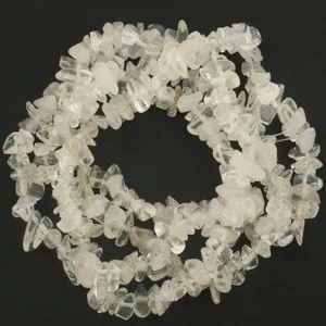 Vista detallada de cuentas de virutas de cristal de cuarzo blanco irregular, ideal para bricolaje.
