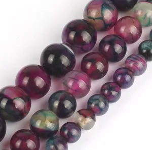 Gros plan detaille de perles en agate fissuree avec de superbes motifs violets et verts.