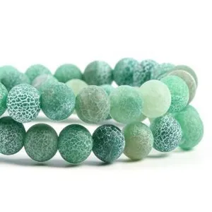 Detailed macro shot of green weathered agate beads, showing unique cracked texture and vibrant tone.