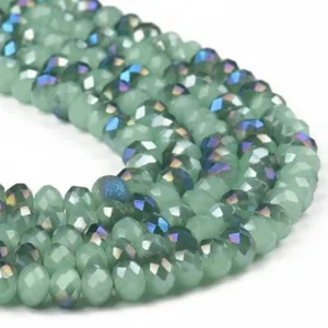 Close-up detail of green faceted crystal rondelle beads with AB color shimmer, ideal for jewelry.