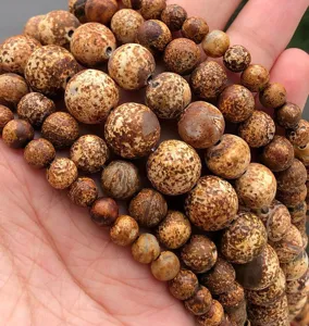 Detailed close-up view of natural speckled gemstone loose beads showing unique texture and pattern.