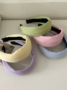 Detail view of assorted pastel ribbed wide headbands for hair in cream and soft colors