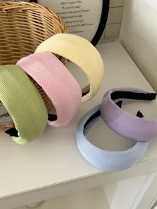 Close-up of five pastel wide-brimmed padded headbands with elegant ribbed knit texture