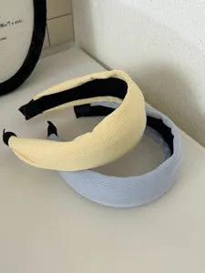 Macro view of cream and light blue pleated wide headbands with elegant knit texture