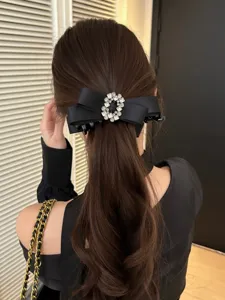 Elegant black satin bow hair banana clip with luxury rhinestone buckle detail shown on hair